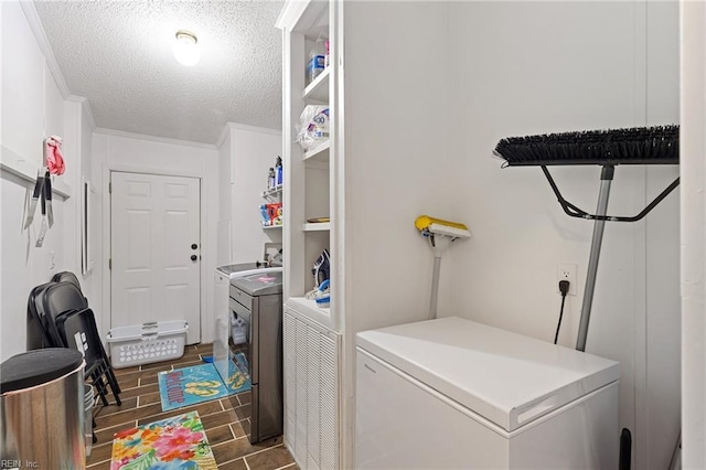 laundry room featuring dark hardwood / wood-style flooring, washer and dryer, a textured ceiling, and ornamental molding