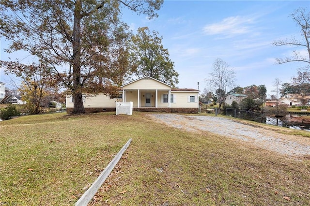 view of front of house with a front yard, covered porch, and a water view