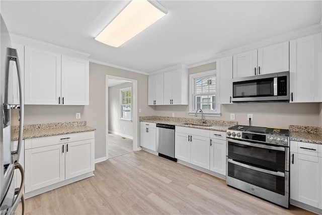 kitchen featuring a healthy amount of sunlight, white cabinetry, sink, and appliances with stainless steel finishes