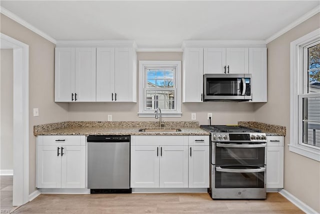 kitchen featuring appliances with stainless steel finishes, white cabinetry, and sink