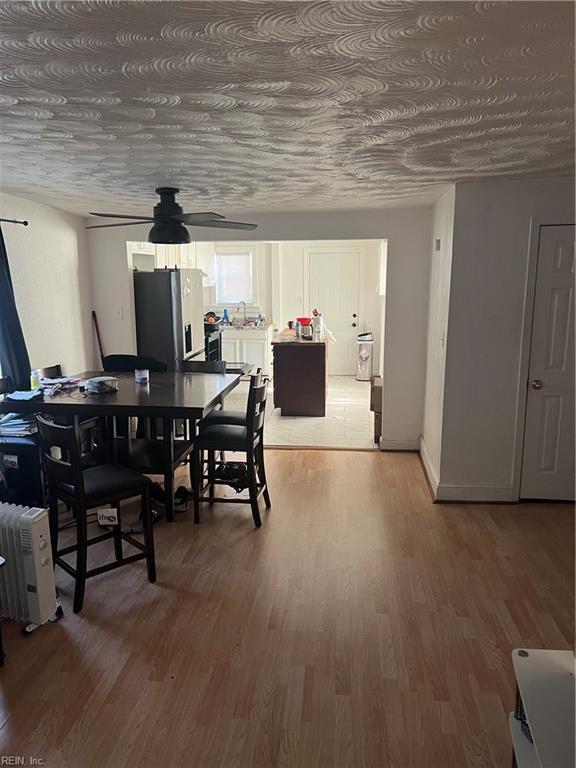 dining area with light wood-style floors and ceiling fan