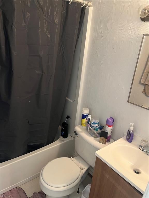 bathroom with toilet, shower / bath combo with shower curtain, and vanity