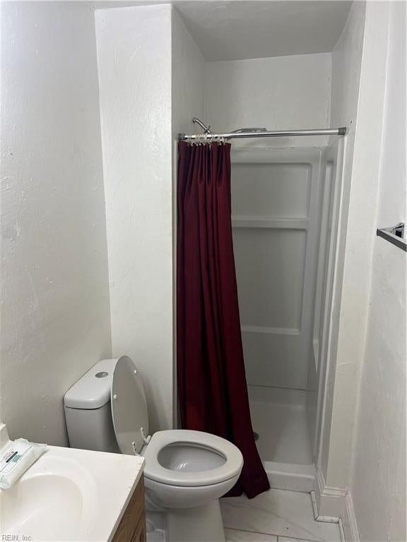 bathroom featuring a stall shower, vanity, and toilet