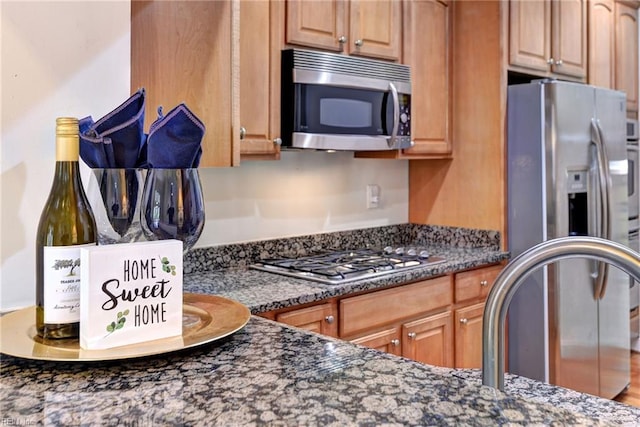 kitchen featuring dark stone countertops and appliances with stainless steel finishes