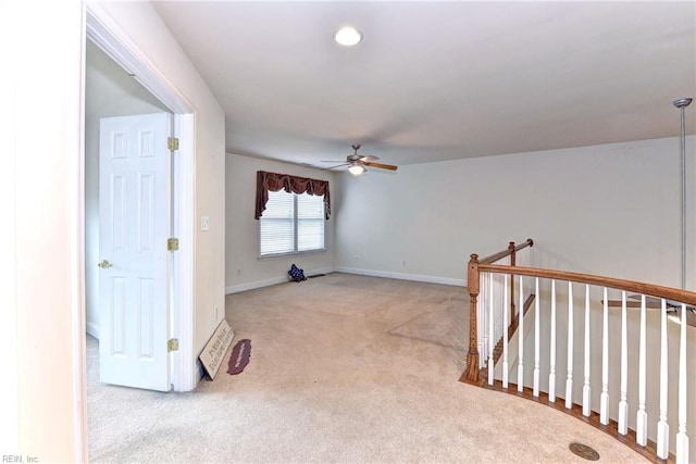 carpeted spare room featuring ceiling fan