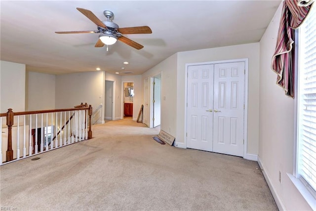 carpeted spare room with ceiling fan