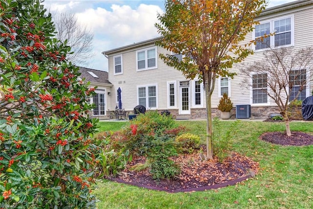 rear view of property with a yard and cooling unit