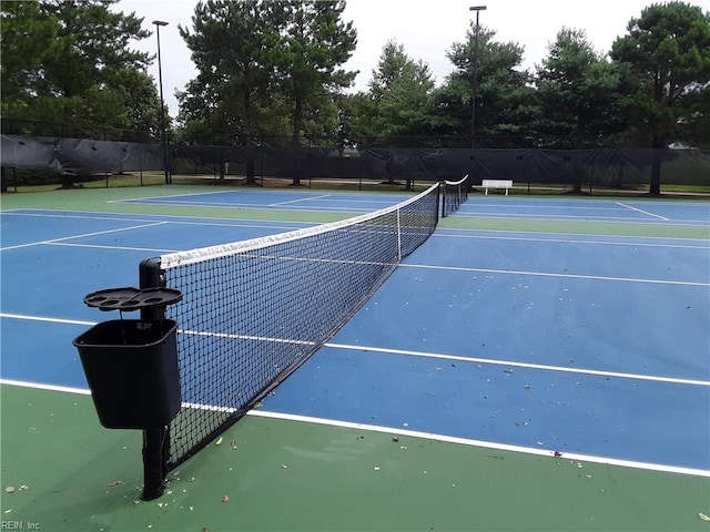 view of tennis court with basketball hoop