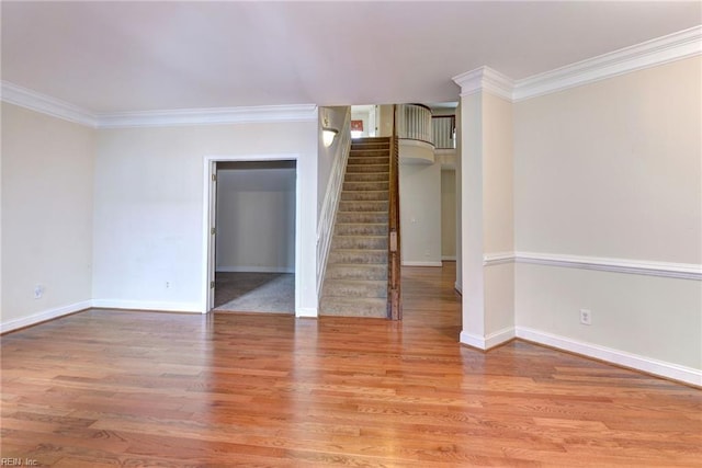 empty room with light hardwood / wood-style floors and crown molding