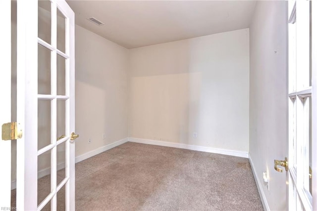 empty room featuring a wealth of natural light and light carpet