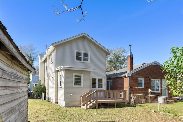 rear view of property featuring a deck and a yard