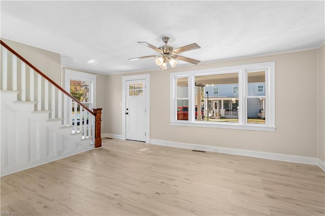 foyer entrance with ceiling fan, light hardwood / wood-style floors, a healthy amount of sunlight, and crown molding