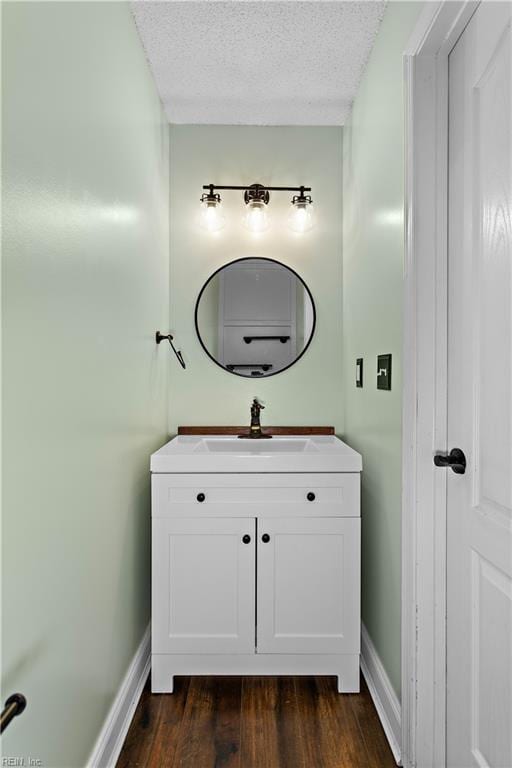 bathroom with vanity, hardwood / wood-style floors, and a textured ceiling