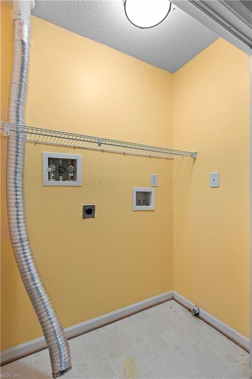 laundry area with hookup for an electric dryer, hookup for a washing machine, and a textured ceiling