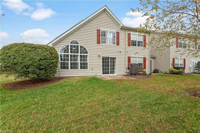 rear view of house with a yard and central AC