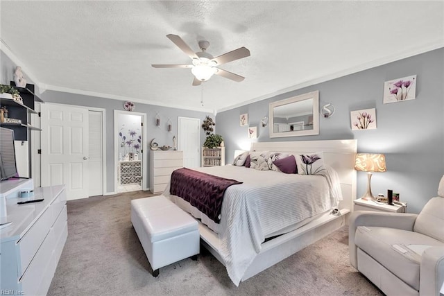 carpeted bedroom featuring a textured ceiling, ensuite bathroom, ceiling fan, and ornamental molding