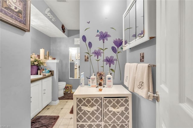 bathroom featuring tile patterned flooring, vanity, and toilet