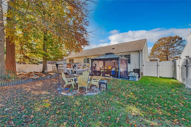 rear view of property featuring a gazebo, a yard, and a wooden deck