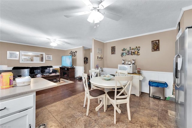 dining room with hardwood / wood-style floors, a textured ceiling, ceiling fan, and ornamental molding