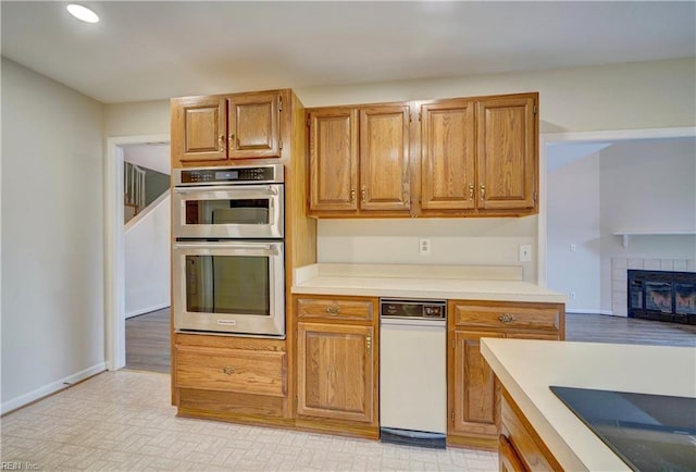 kitchen featuring stainless steel double oven and a tiled fireplace