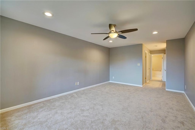 spare room featuring ceiling fan and light colored carpet