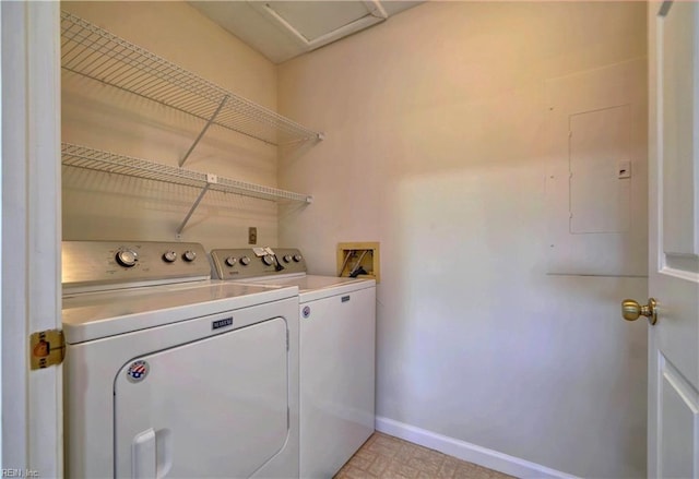 clothes washing area with washer and clothes dryer and electric panel