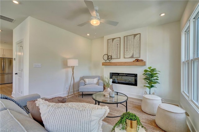 living room featuring light hardwood / wood-style flooring and ceiling fan