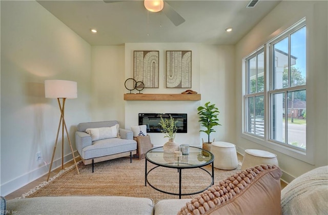 living room featuring ceiling fan, wood-type flooring, and a wealth of natural light
