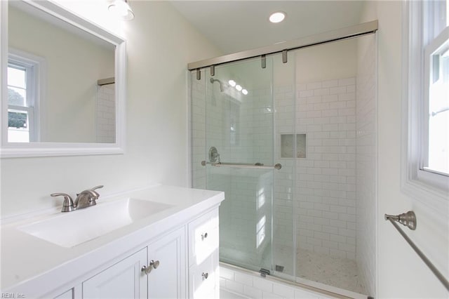 bathroom with vanity and a shower with door