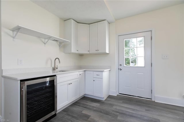 kitchen with wine cooler, white cabinetry, sink, and dark wood-type flooring