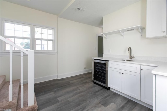 interior space featuring wine cooler, white cabinetry, sink, and dark hardwood / wood-style flooring