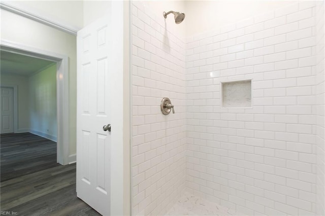 bathroom featuring a tile shower and hardwood / wood-style floors