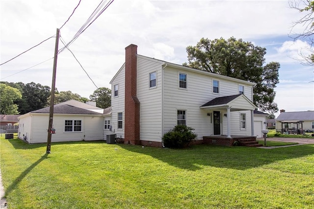 view of front of house featuring cooling unit, a garage, and a front yard