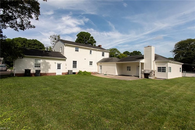 rear view of property with a lawn and a patio