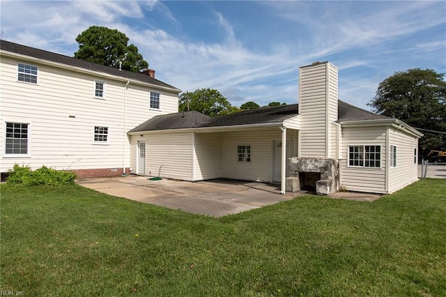 rear view of property featuring a lawn and a patio area