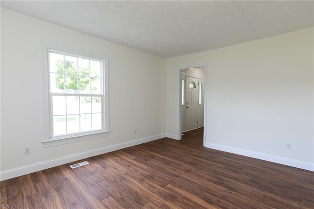 spare room with dark hardwood / wood-style flooring