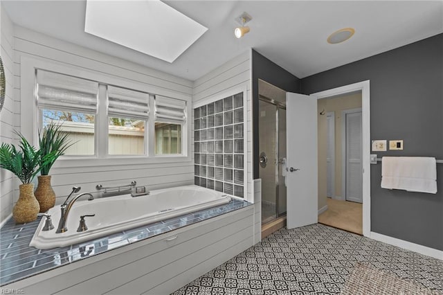 bathroom featuring shower with separate bathtub and a skylight