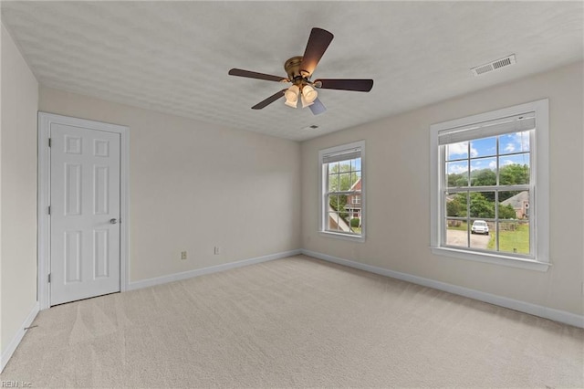 unfurnished room with ceiling fan and light carpet