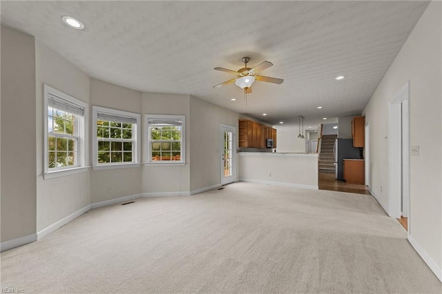 unfurnished living room with ceiling fan and light colored carpet