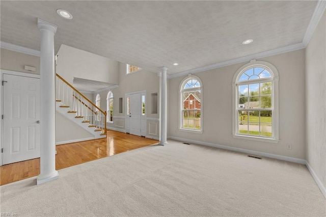 foyer entrance featuring light colored carpet and decorative columns