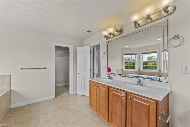 bathroom featuring tile patterned flooring, vanity, and a bathtub