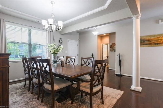 dining area with a chandelier, dark hardwood / wood-style floors, a raised ceiling, and decorative columns