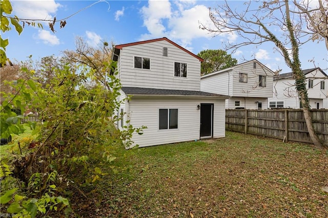 rear view of house featuring a yard