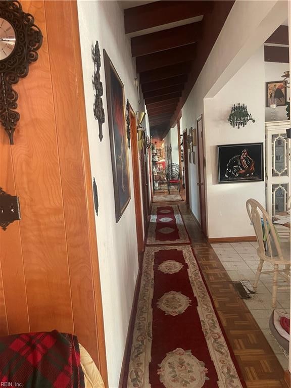 hallway with beam ceiling and dark tile patterned floors