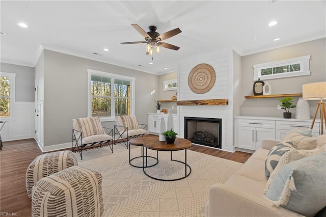 living room with plenty of natural light, light hardwood / wood-style floors, and ornamental molding