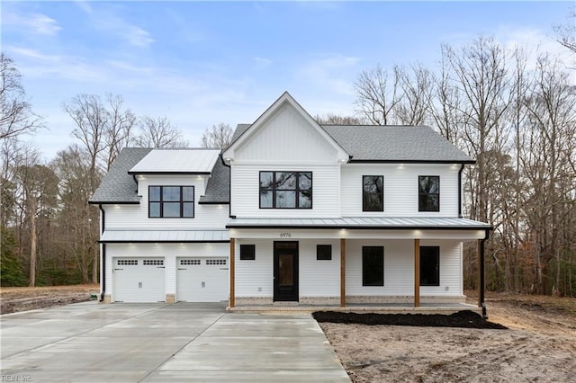 modern farmhouse style home featuring covered porch and a garage