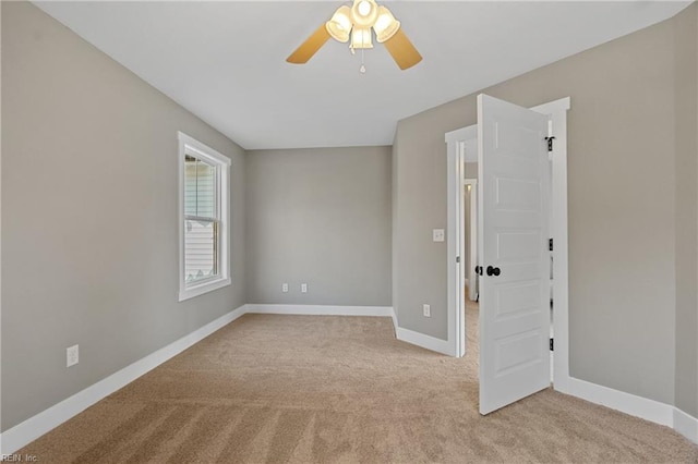 carpeted spare room with ceiling fan