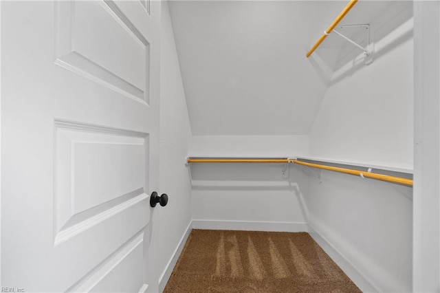 walk in closet featuring dark carpet and vaulted ceiling