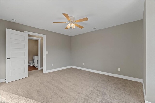 unfurnished bedroom with light colored carpet, ceiling fan, and ensuite bathroom