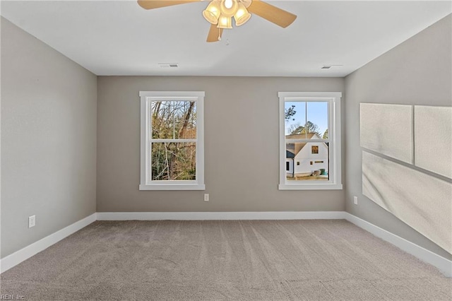 spare room featuring light carpet, ceiling fan, and a healthy amount of sunlight